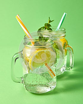 Two mason jars with a cold natural handmade cocktail with bubbles of air. Refreshing drink from natural ingredient -