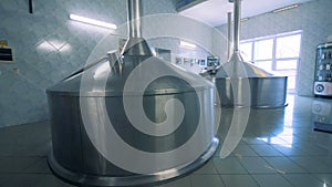 Two massive canisters placed in a hall of a brewery factory