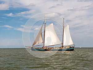 Two-masted clipper and brown fleet charter ship sailing on IJsselmeer lake, Netherlands