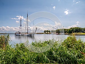 Two-masted sailing ship entering harbour of Trintelhaven on Houtribdijk between Lelystad and Enkhuizen, Netherlands