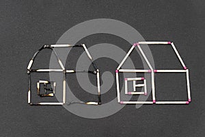 Two match houses made of burnt and unburnt matchsticks on a black background.Creative flat lay composition. photo