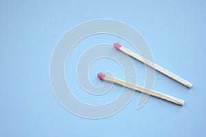 Two matches on a blue paper table