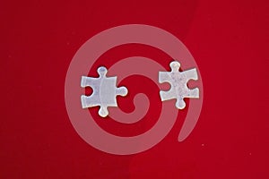 two matching disconnected jigsaw puzzles on a red background.