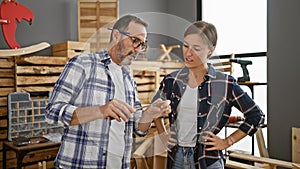 Two mates in the carpentry biz, a man and a woman, chinwagging while the timber whispers