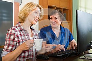 Two mature female browsing web