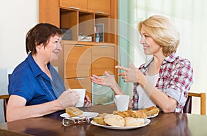 Two mature female drinking tea