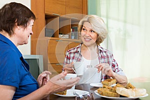 Two mature female drinking tea