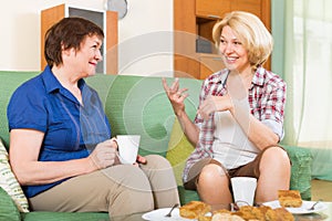 Two mature female drinking tea