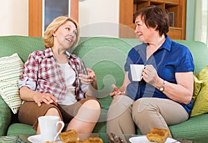 Two mature female drinking tea