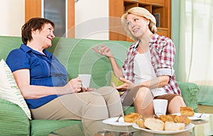 Two mature female drinking tea