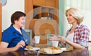 Two mature female drinking tea