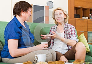 Two mature female drinking tea