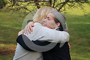 Two mature friends hugging