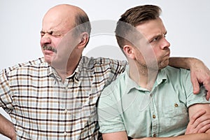 Two mature men father and son are offended on each other. Have a disagreement