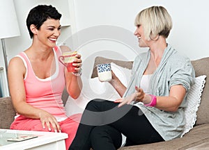 Two mature woman friends chating over coffee