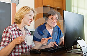 Two mature women browsing web