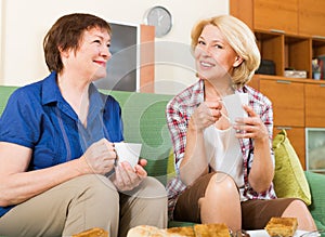 Two mature women drinking tea