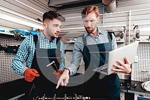 Two Mechanics Work Together On Service Station.