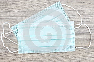 Two medical hygienic face masks on wooden background