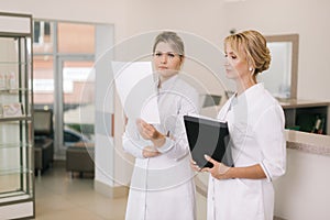 Two medical professionals woman doctor talking in the corridor hospital