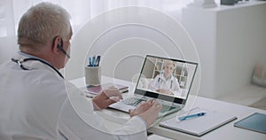 Two medical specialists are chatting online by web camera, consulting and exchanging information