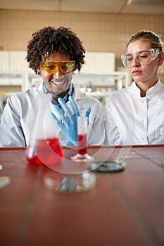 Two medical students conducting chemical experiment