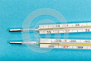 Two medical  thermometer  on blue  background close up view