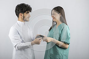 Two medical workers holding their mask and lookin each others