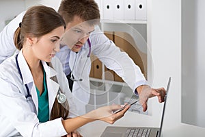 Two medicine doctors looking at laptop monitor