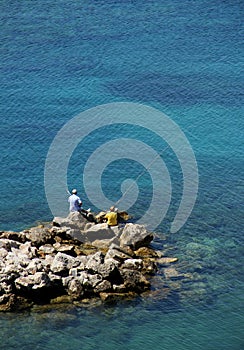 Two men angling seashore photo