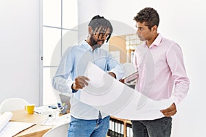 Two men architect workers looking blueprint standing at architecture studio