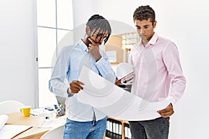 Two men architect workers looking blueprint standing at architecture studio