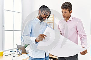 Two men architect workers looking blueprint standing at architecture studio