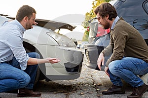 Two men arguing after a car accident on the road