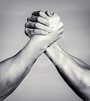 Two men arm wrestling. Arms wrestling. Closep up. Friendly handshake, friends greeting, teamwork, friendship. Handshake