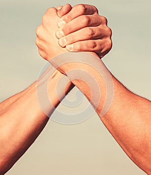 Two men arm wrestling. Arms wrestling. Closep up. Friendly handshake, friends greeting, teamwork, friendship. Handshake