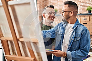 Two men artists smiling confident drawing at art studio