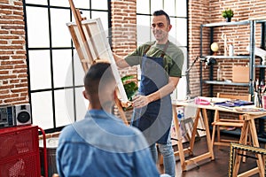 Two men artists smiling confident drawing portrait at art studio