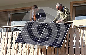 Two men assemble a balcony power plant to generate electricity