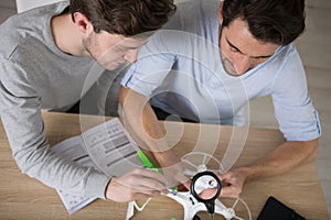 two men assembling drone at home