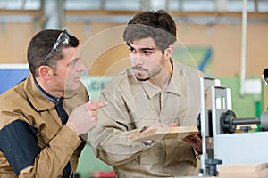 two men assembling product in carpentry workshop