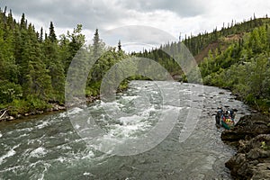 Canoe and turbulent rapids on an Alaskan river