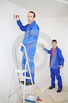 Two men in blue, pasting paint fiberglass and photo