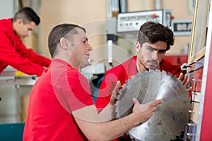 Two men builder with circular saw having conversation