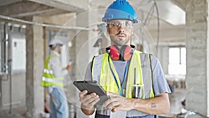 Two men builders using touchpad at construction site