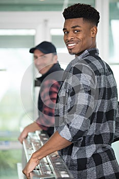 two men carrying ladder