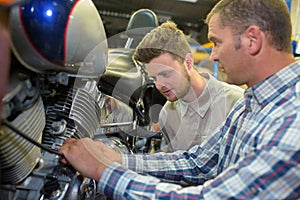 two men checking motorbike