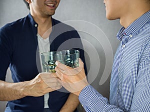 Two men clinking glasses and partying close up