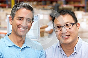 Two Men At Computer Terminal In Distribution Warehouse