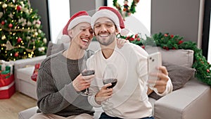 Two men couple celebrating christmas drinking wine having video call at home